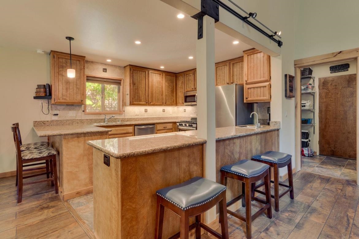 730 Cascade Circle Homewood, CA 96141 - Photo 6 of 22 a kitchen with stainless steel appliances kitchen island granite countertop a table chairs and a refrigerator