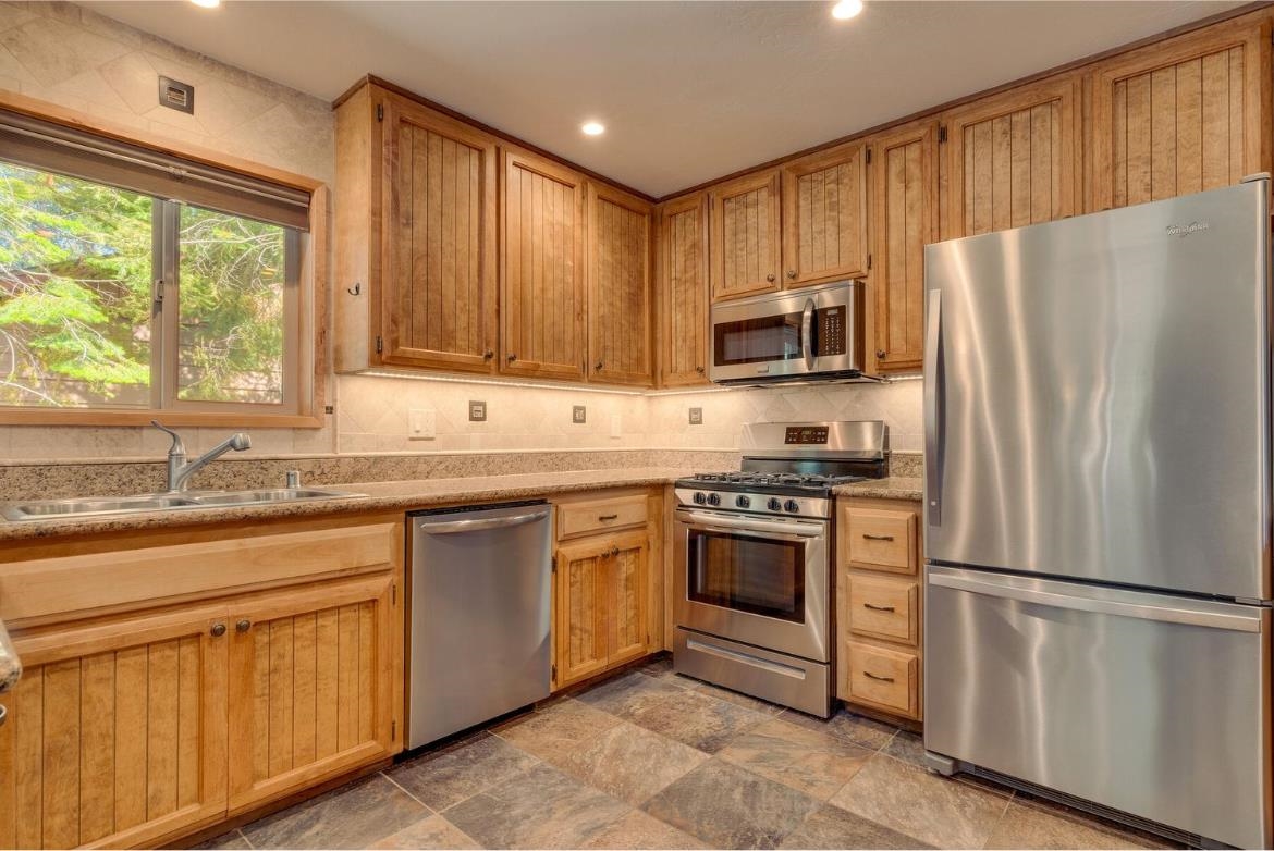 730 Cascade Circle Homewood, CA 96141 - Photo 7 of 22 a kitchen with granite countertop stainless steel appliances a refrigerator cabinets and a window