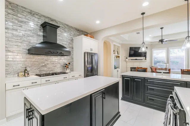 a kitchen with kitchen island a sink appliances and a counter top space