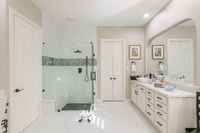 a bathroom with a double vanity sink mirror and shower