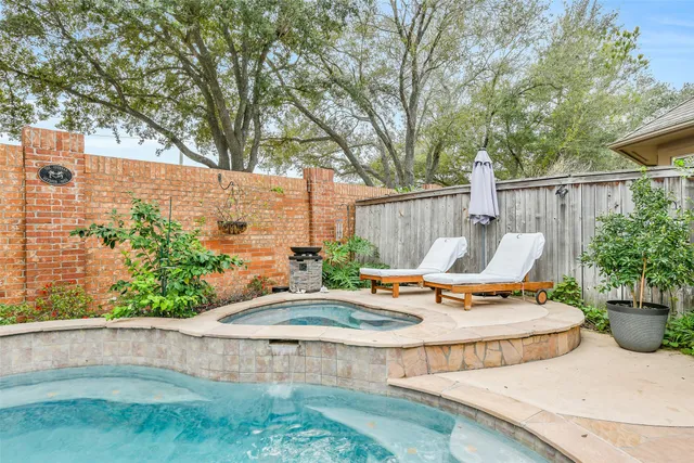 a view of a backyard with plants and chairs