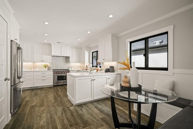 a kitchen with white cabinets and stainless steel appliances