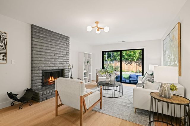 a living room with furniture a fireplace and a large window