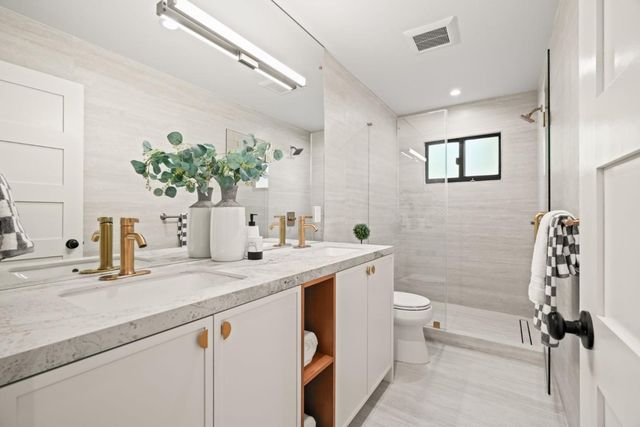 a bathroom with a sink a toilet and shower