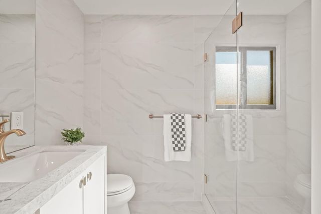 a bathroom with a sink a toilet and shower