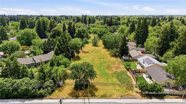 an aerial view of residential houses with outdoor space and trees