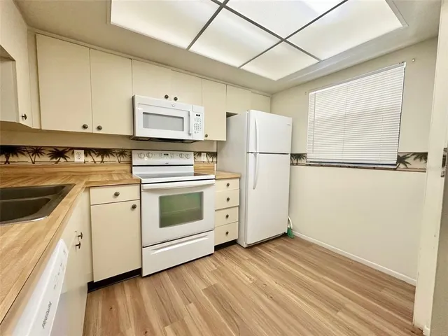 a kitchen with a white cabinets and white appliances