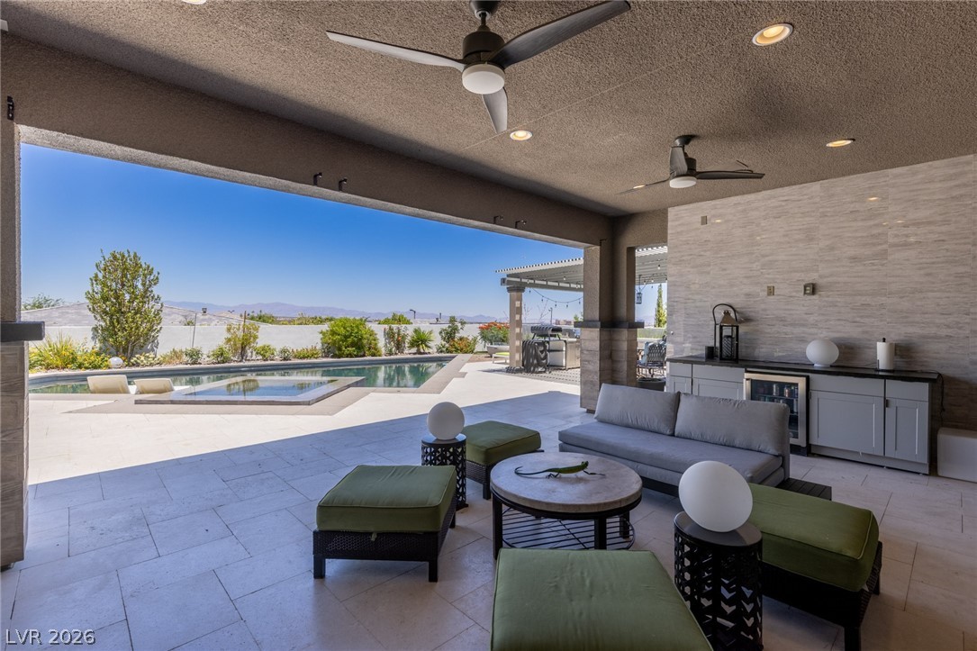 10118 Copper Edge Road Las Vegas, NV 89148 - Photo 40 of 48 An inviting covered patio with a well-appointed outdoor kitchen overlooks the sparkling pool and distant mountain scenery.