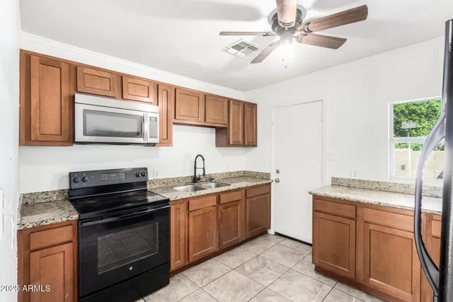 a kitchen with granite countertop a sink and a stove
