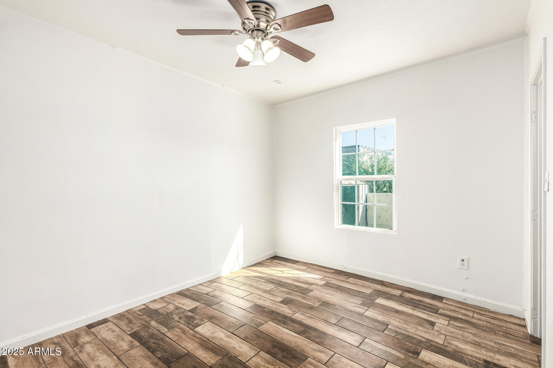 1010 East Chipman Road Phoenix, AZ 85040 - Photo 18 of 23 an empty room with a window and a fan