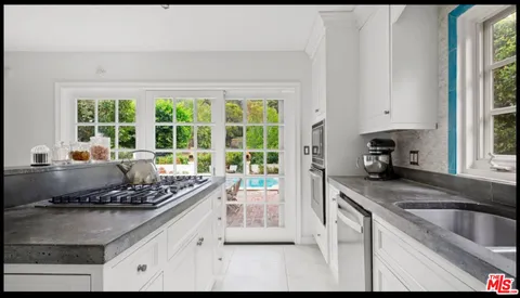 a kitchen with a stove a sink and a granite counter tops