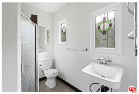 a bathroom with a toilet a sink and mirror
