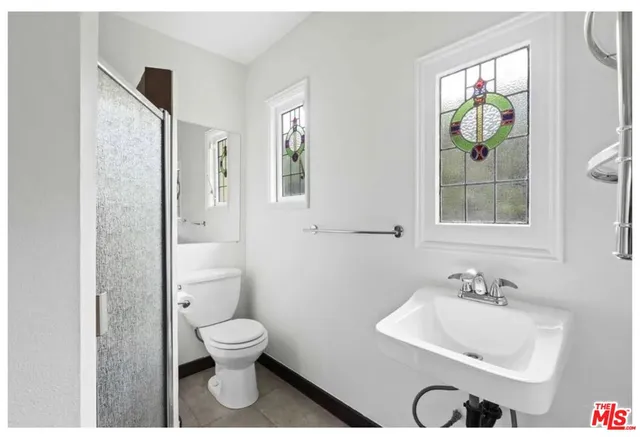 a bathroom with a toilet a sink and mirror