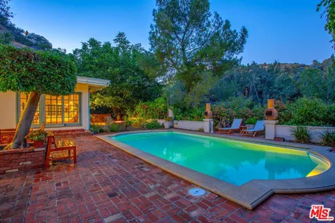 an outdoor space with swimming pool and furniture