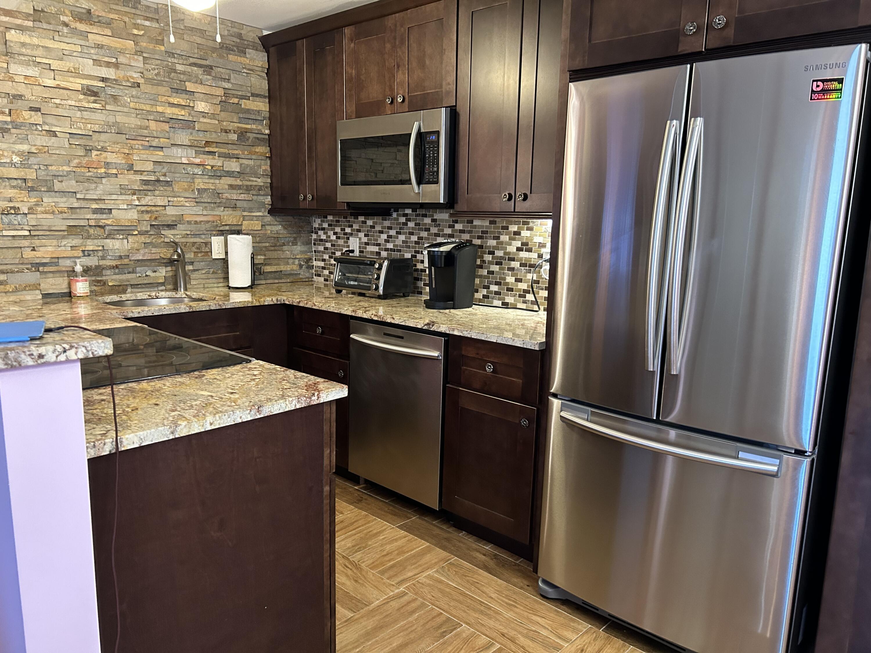 3070 Cornwall East, Unit 3070D Boca Raton, FL 33434 - Photo 1 of 22 a kitchen with granite countertop stainless steel appliances and refrigerator