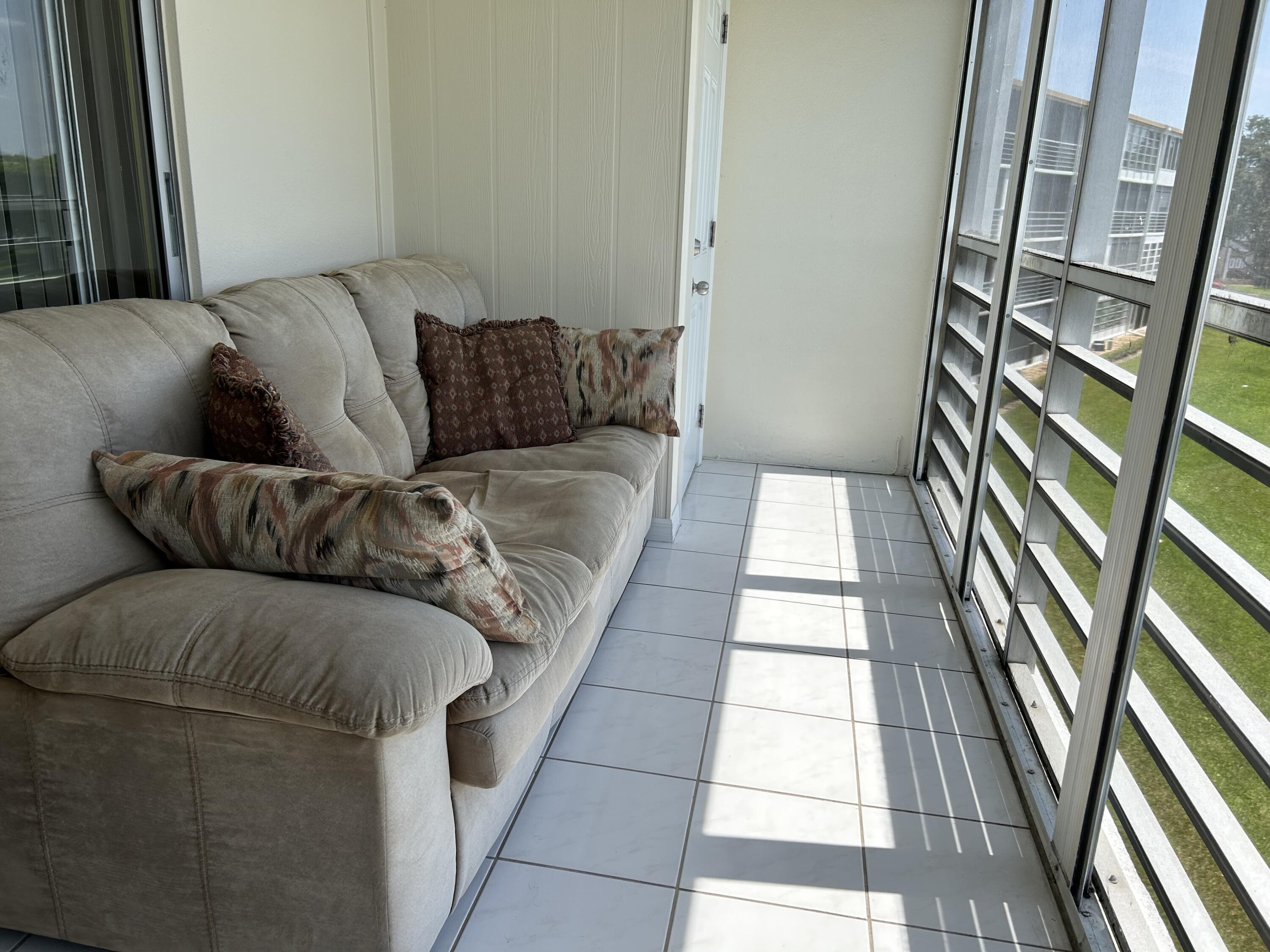 3070 Cornwall East, Unit 3070D Boca Raton, FL 33434 - Photo 12 of 22 a living room with a couch and a rug