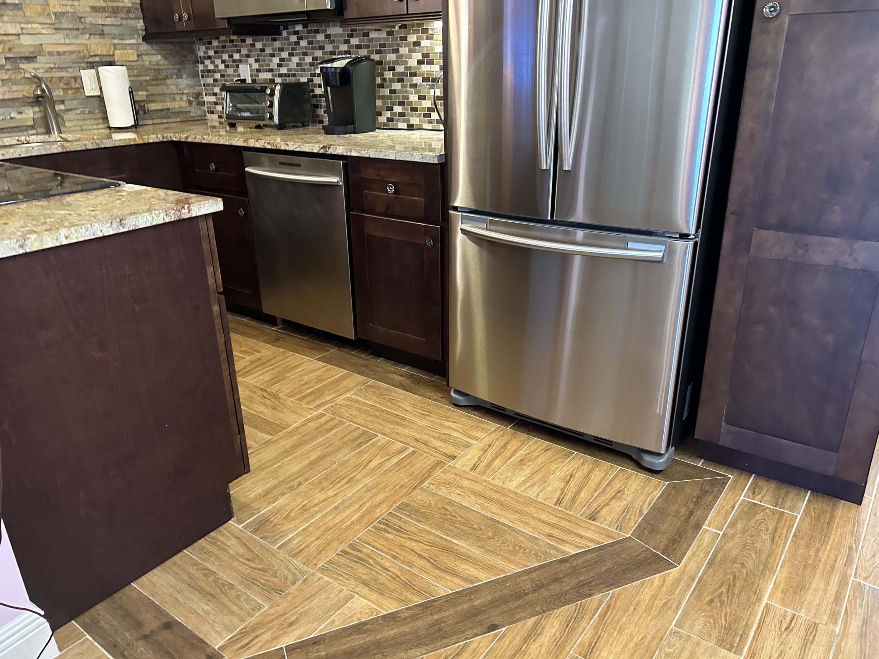 3070 Cornwall East, Unit 3070D Boca Raton, FL 33434 - Photo 3 of 22 a kitchen with a sink and wooden cabinets