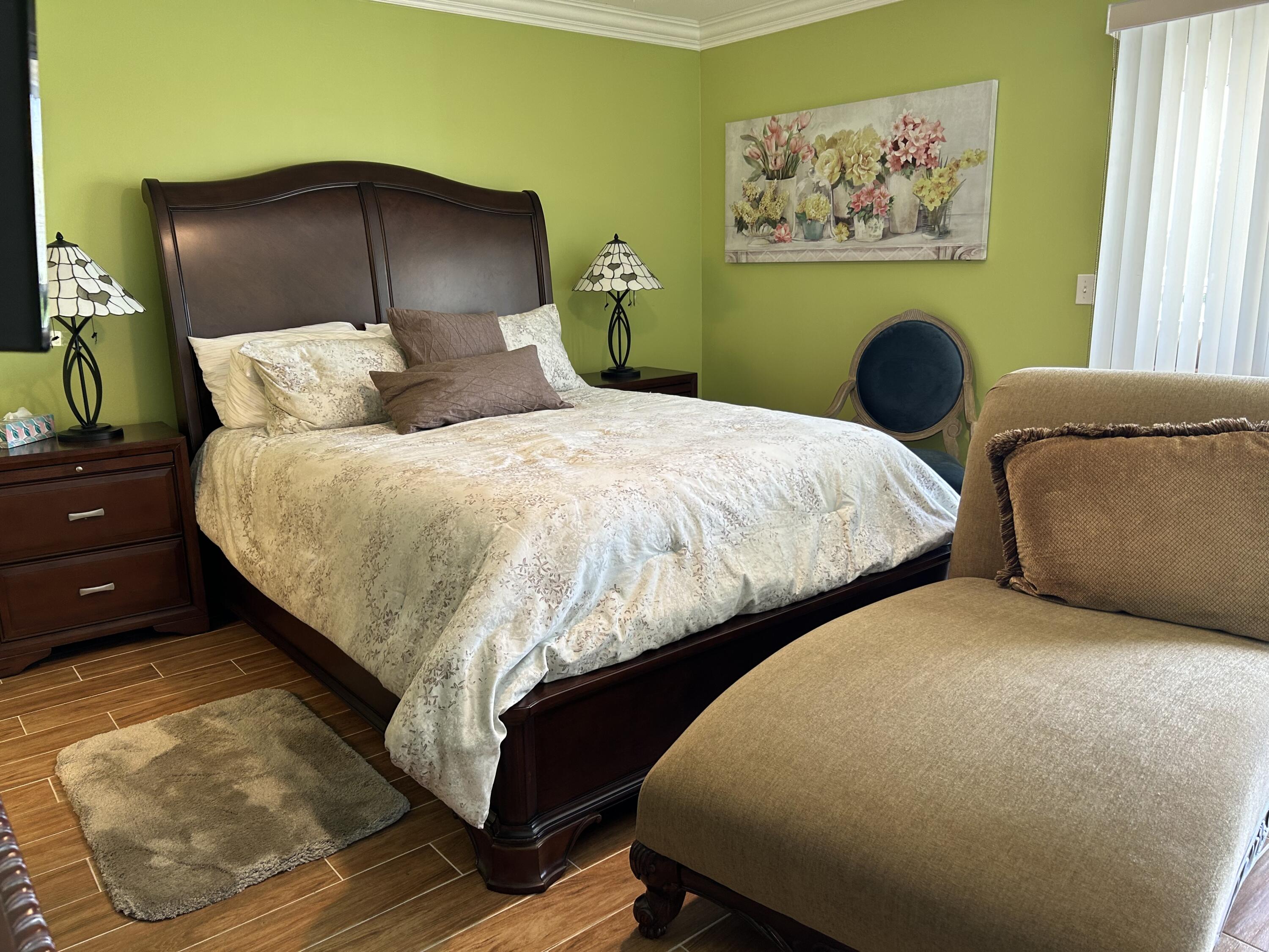 3070 Cornwall East, Unit 3070D Boca Raton, FL 33434 - Photo 8 of 22 a bed sitting in a bedroom next to a window with painting on the wall