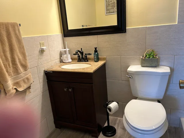 a bathroom with a toilet a sink and mirror