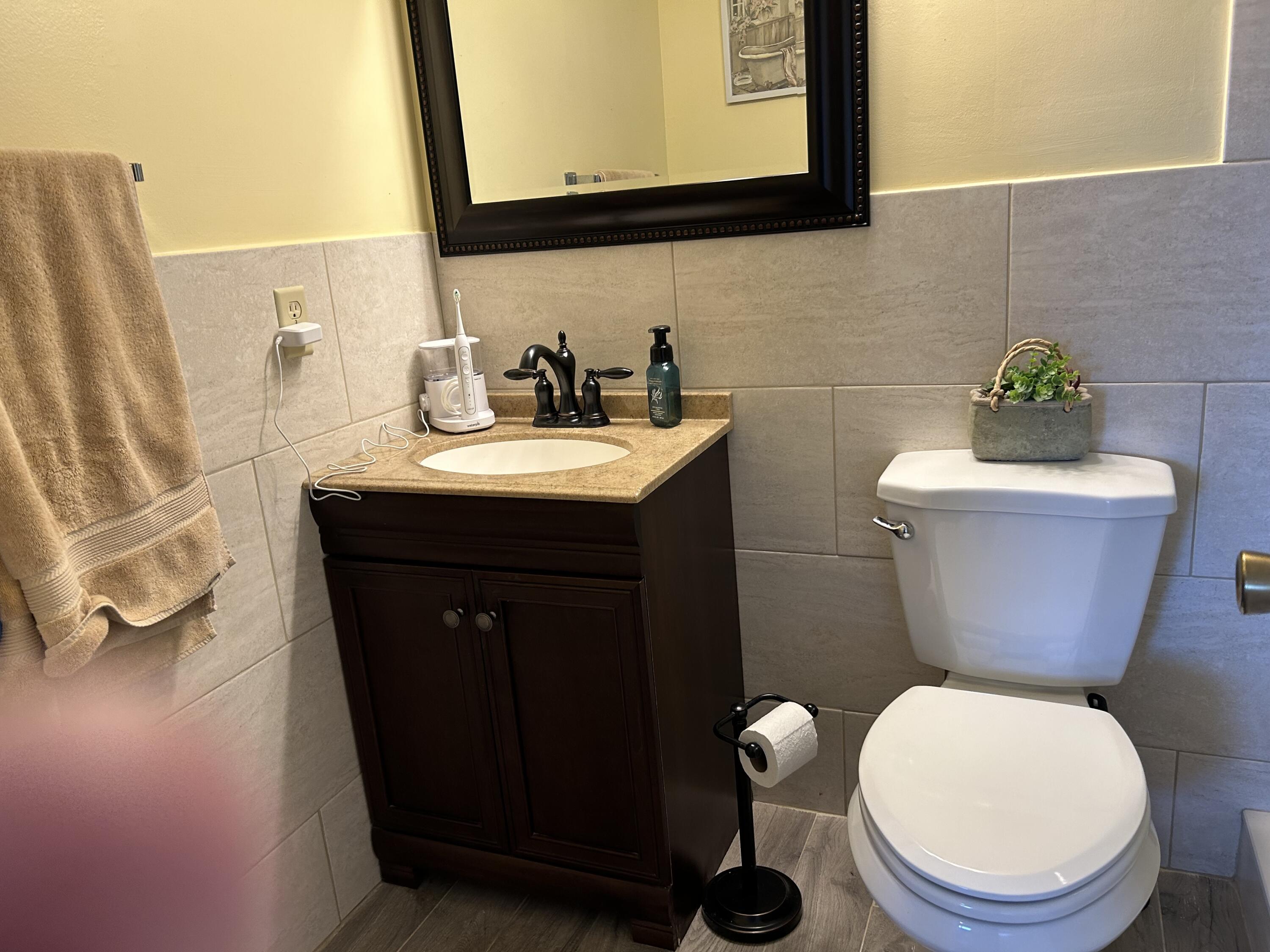 3070 Cornwall East, Unit 3070D Boca Raton, FL 33434 - Photo 10 of 22 a bathroom with a toilet a sink and mirror