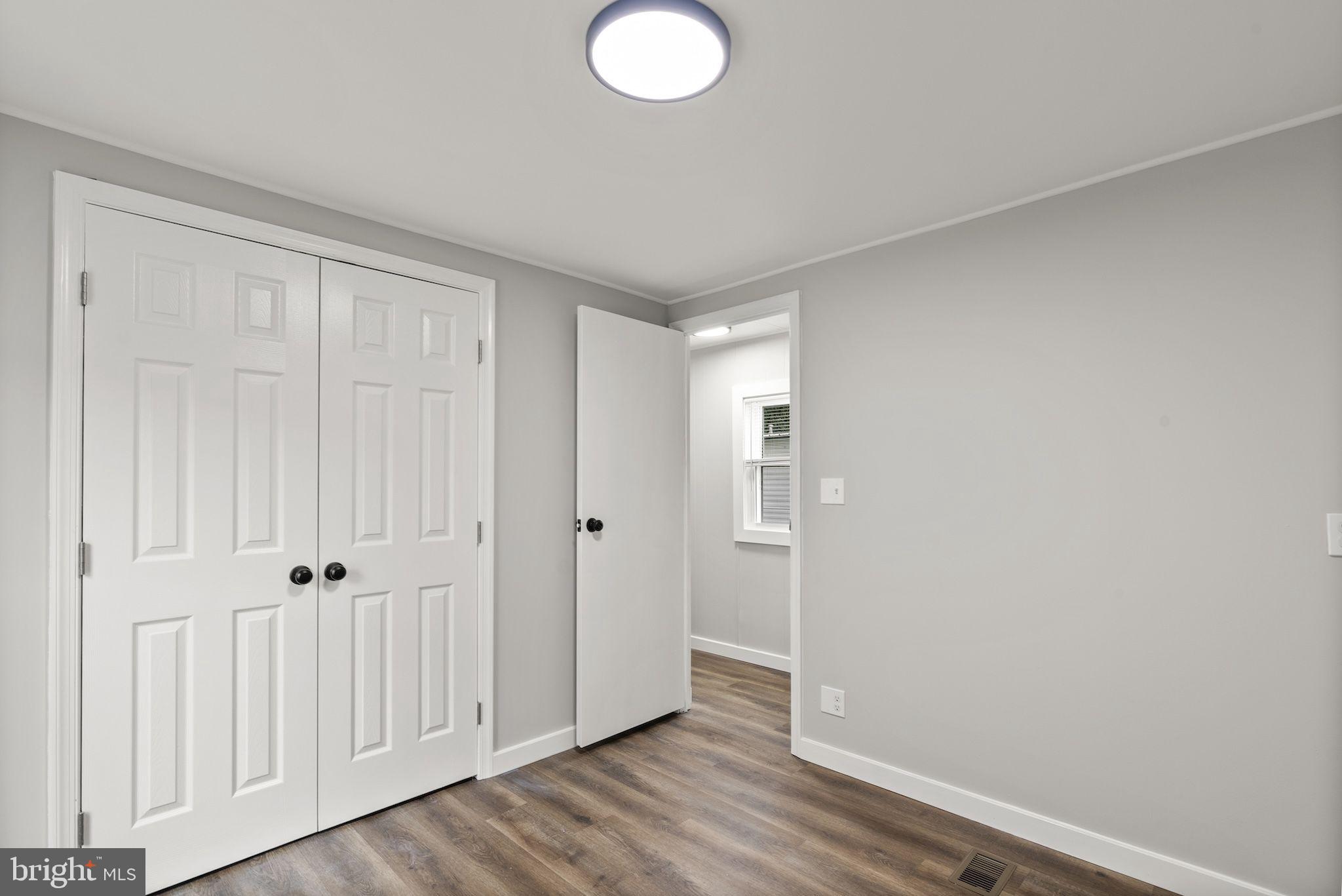 635 Sunset Strip Brooklyn, MD 21225 - Photo 14 of 27 an empty room with wooden floor and closet area