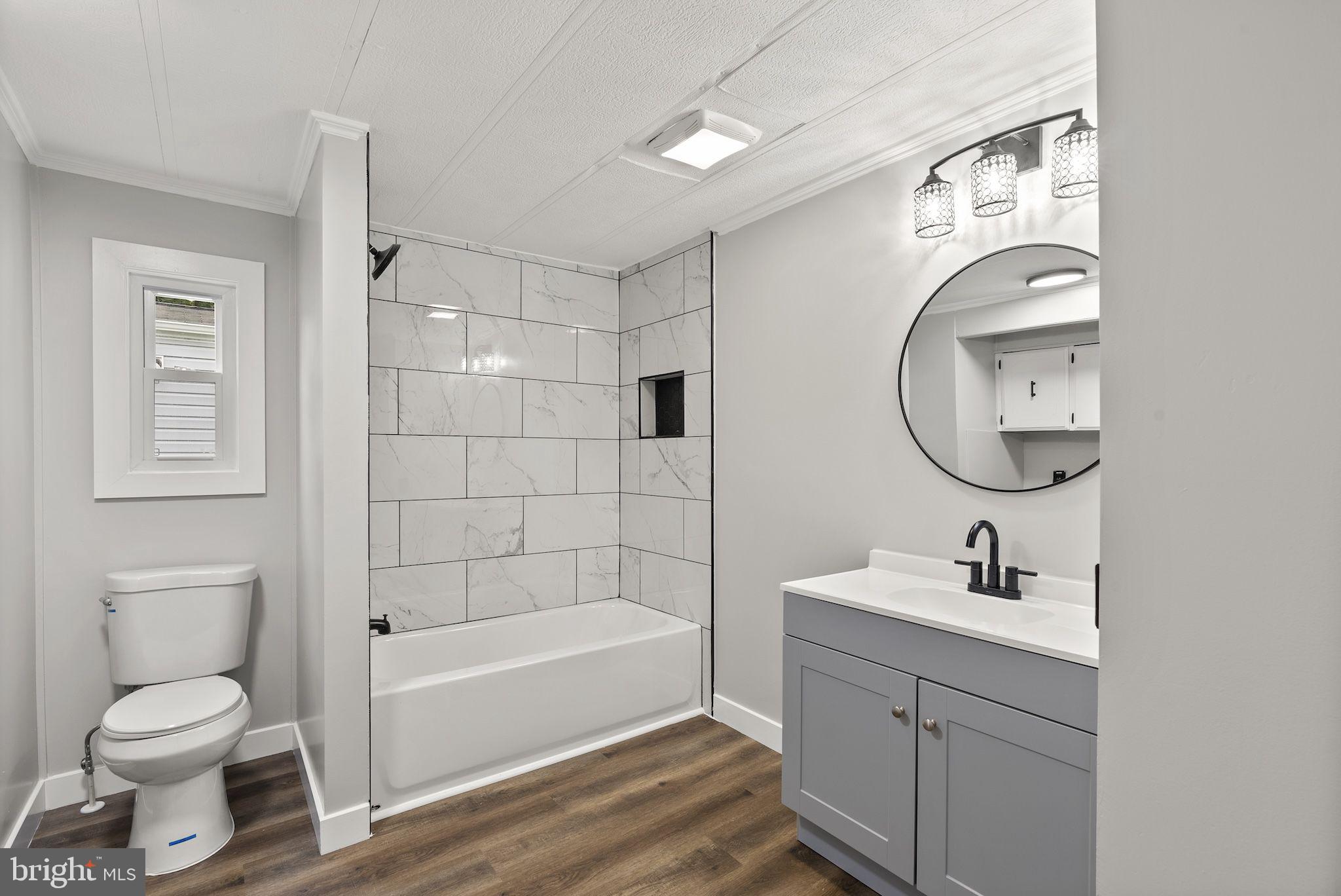 635 Sunset Strip Brooklyn, MD 21225 - Photo 15 of 27 a bathroom with a toilet a sink a mirror and bathtub