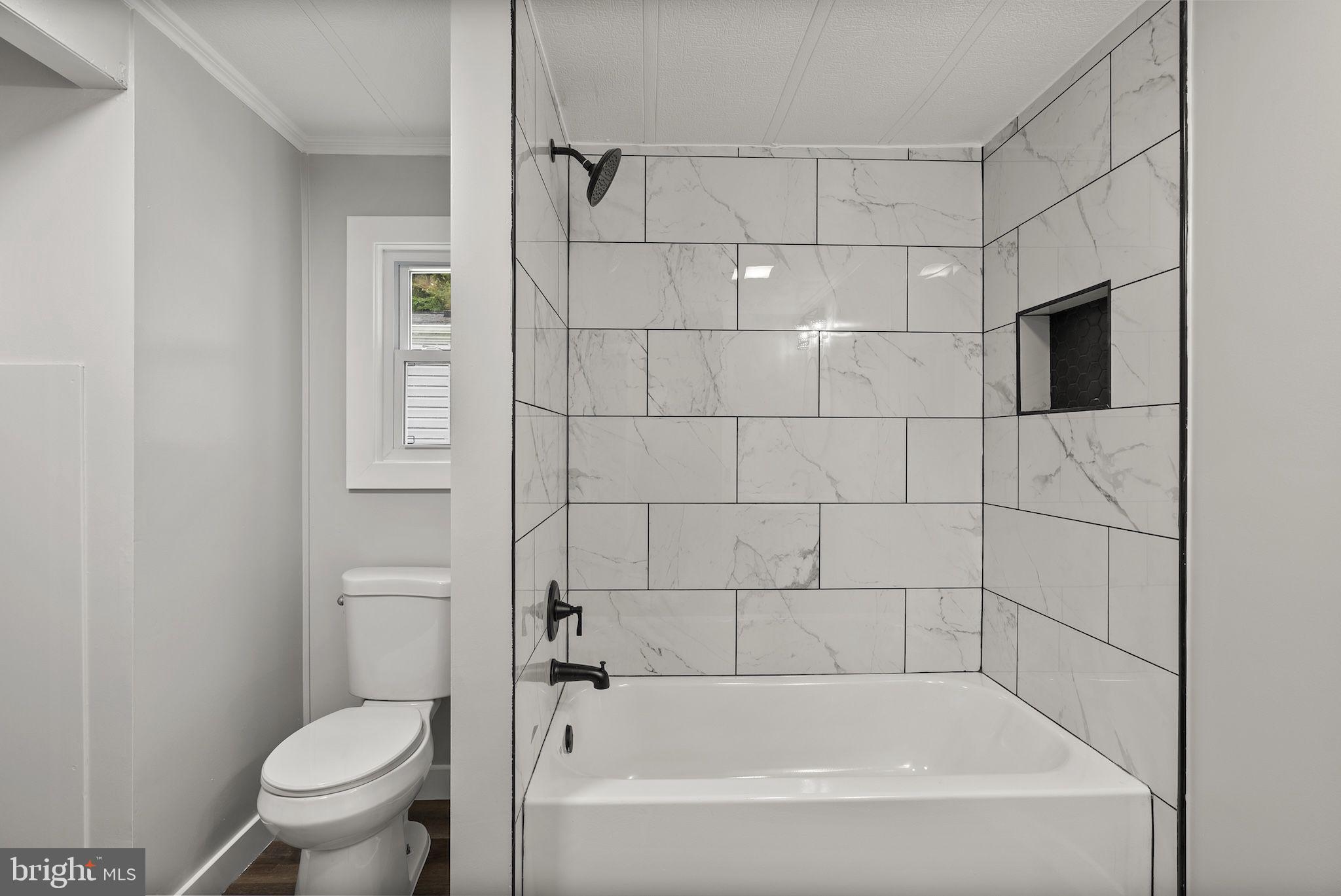 635 Sunset Strip Brooklyn, MD 21225 - Photo 16 of 27 a bath room with a toilet and a bath tub