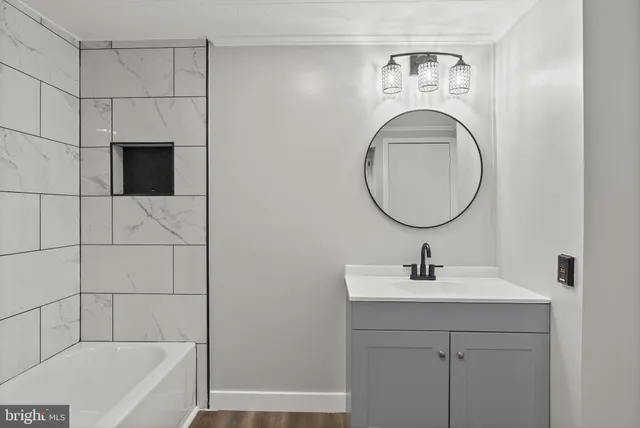 a bathroom with a sink a bathtub and a mirror