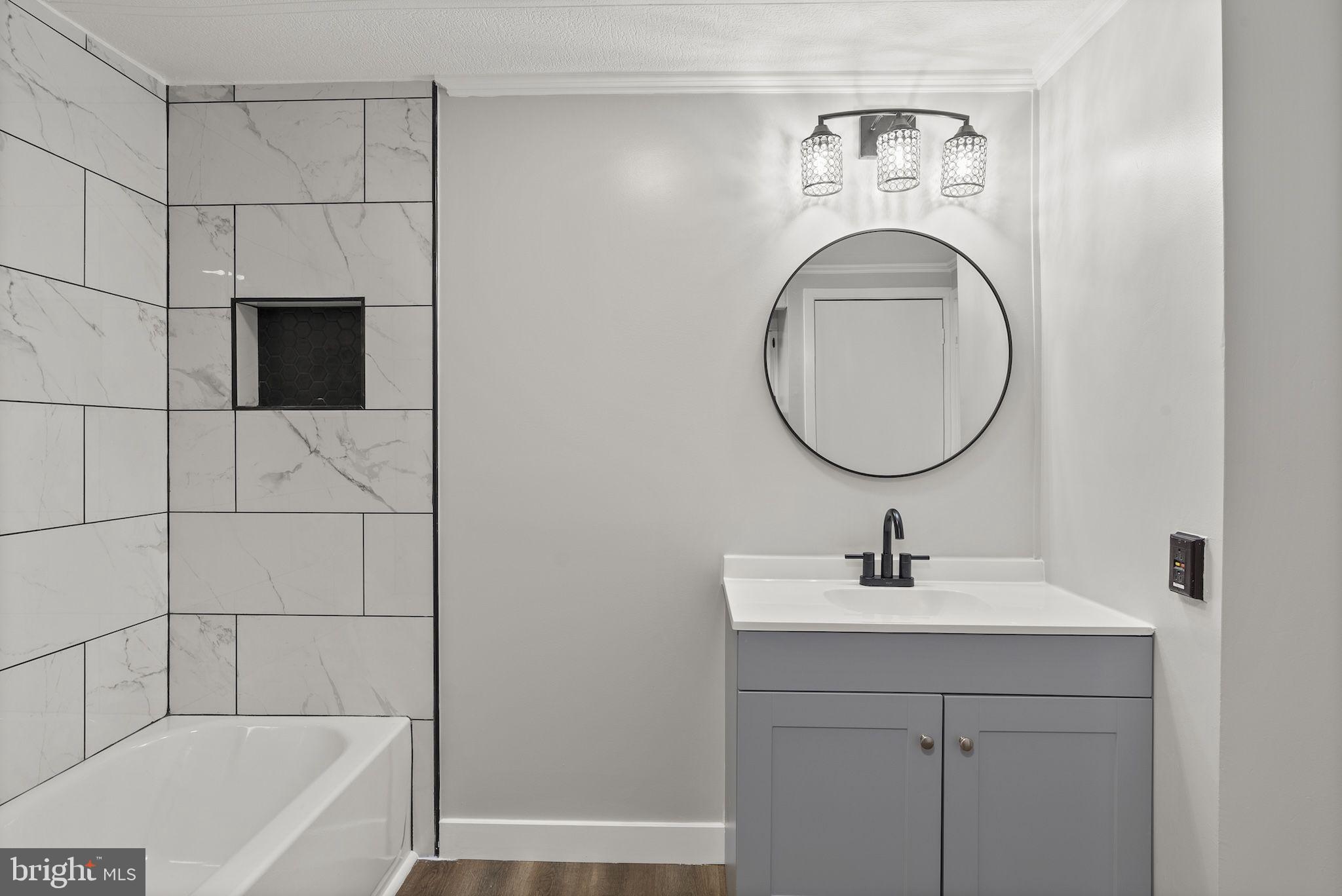 635 Sunset Strip Brooklyn, MD 21225 - Photo 18 of 27 a bathroom with a sink a bathtub and a mirror