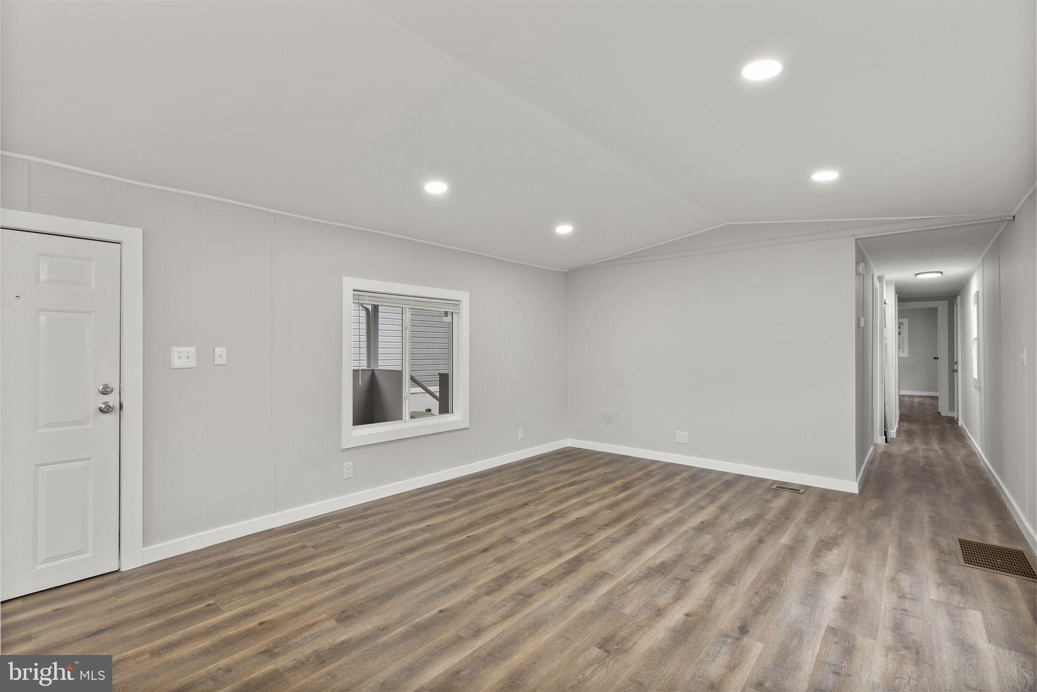 635 Sunset Strip Brooklyn, MD 21225 - Photo 10 of 27 a view of an empty room with wooden floor and a window