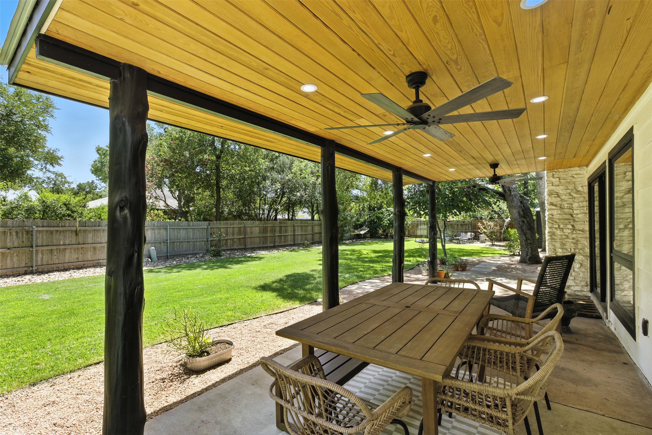 2403 Gateshead Circle Austin, TX 78745 - Photo 5 of 22 An inviting covered patio featuring natural wood ceilings and recessed lighting, perfect for al fresco dining.