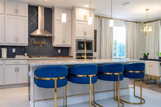a kitchen with kitchen island a dining table chairs and white cabinets