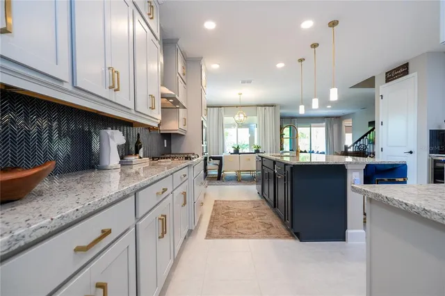a large kitchen with kitchen island a large counter space a sink a window and stainless steel appliances