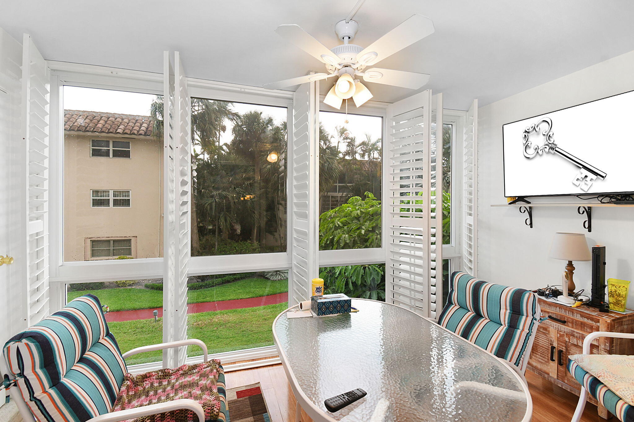 400 Northeast 20th Street, Unit A207 Boca Raton, FL 33431 - Photo 16 of 55 a dining room with furniture a flat screen tv and a floor to ceiling window