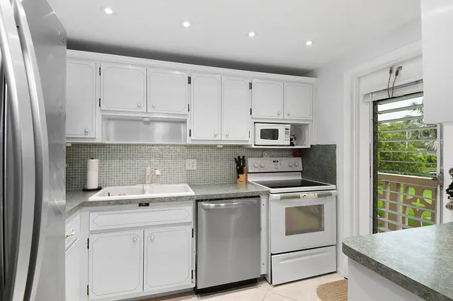 a kitchen with white cabinets and white appliances