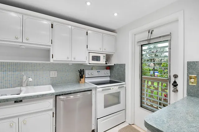 a kitchen with granite countertop a sink stainless steel appliances and cabinets