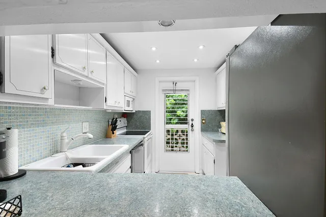 a kitchen with stainless steel appliances granite countertop a sink stove and cabinets