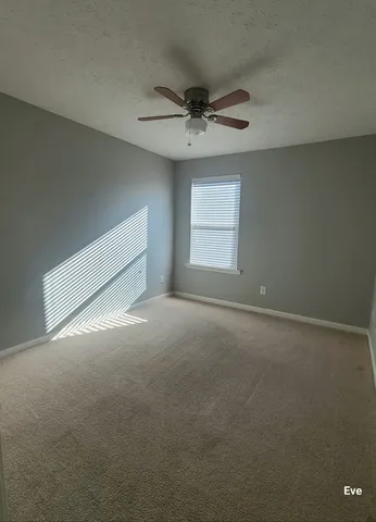 an empty room with a window and a ceiling fan