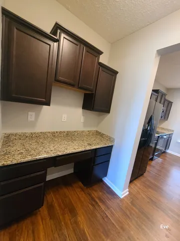 a view of kitchen with stainless steel appliances wooden floor and a counter top space
