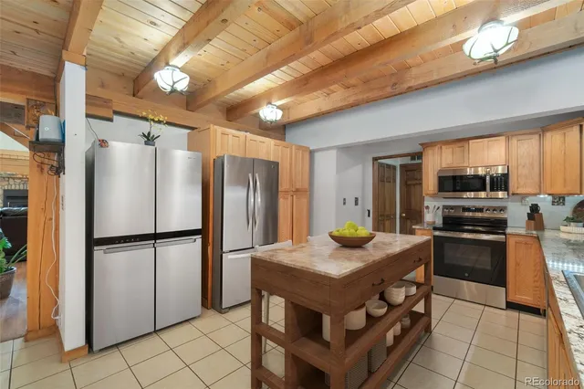 a kitchen with stainless steel appliances granite countertop a refrigerator a stove a sink and a microwave