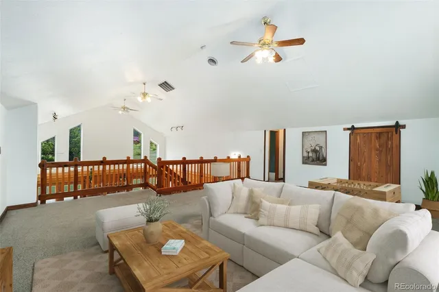 a living room with furniture ceiling fan and a rug