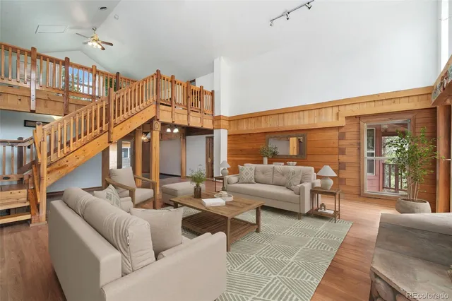 a living room with furniture ceiling fan and a rug