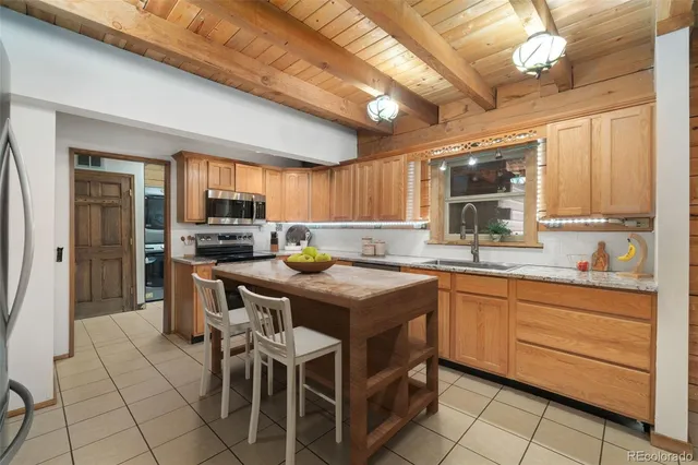 a kitchen with granite countertop a sink counter top space appliances and cabinets