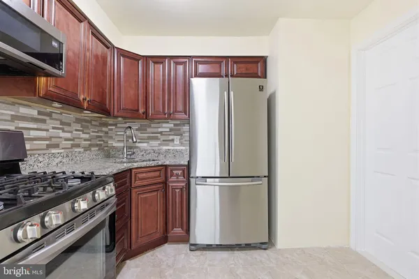 a kitchen with granite countertop a refrigerator stove and microwave