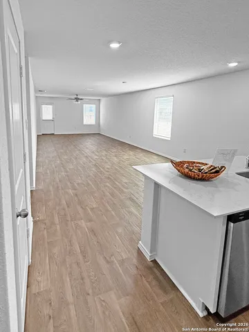 a view of empty room with wooden floor and window