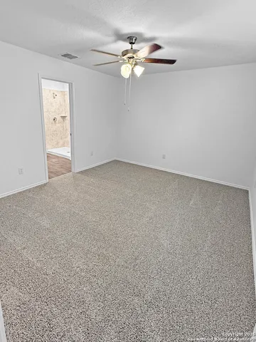 an empty room with chandelier fan