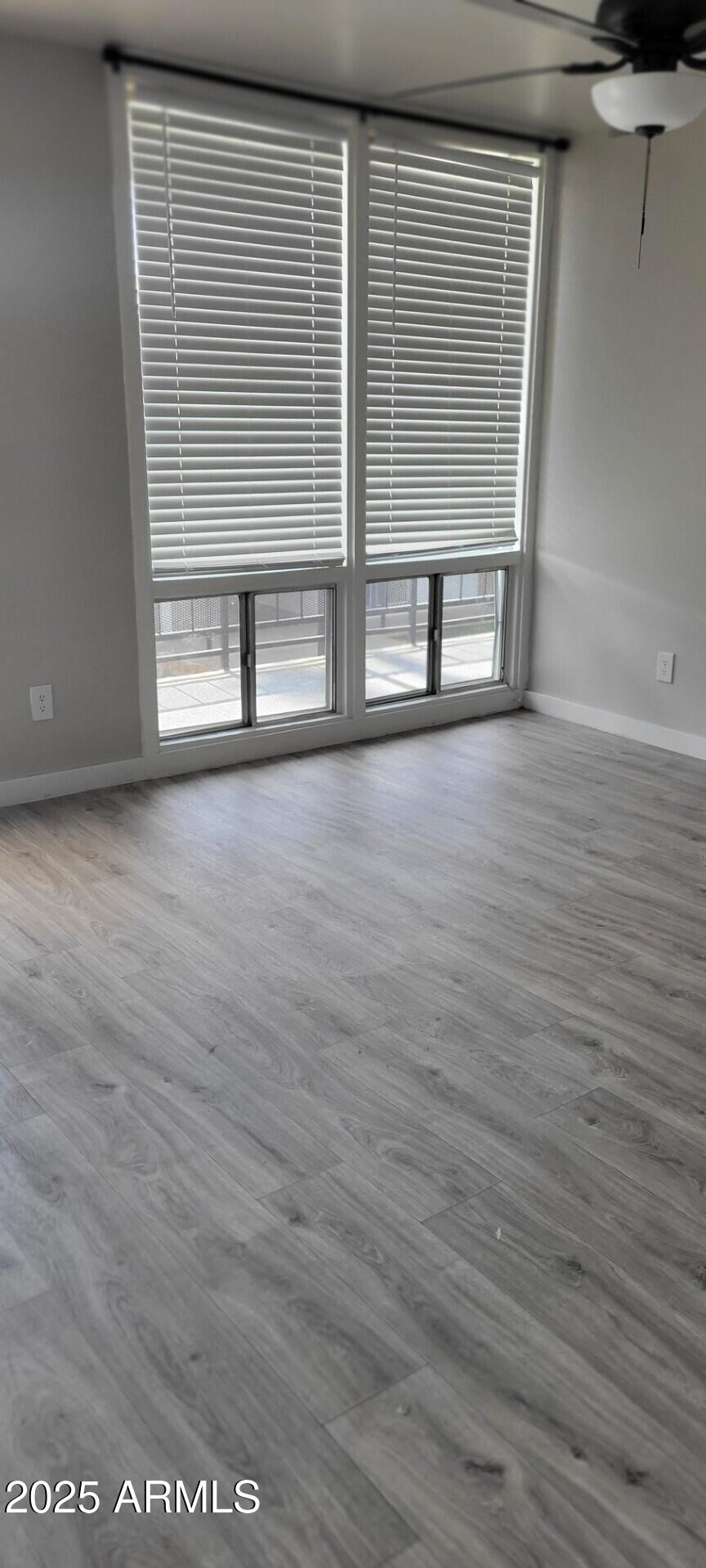 2339 West Northern Avenue, Unit 225 Phoenix, AZ 85021 - Photo 6 of 14 an empty room with wooden floor and windows