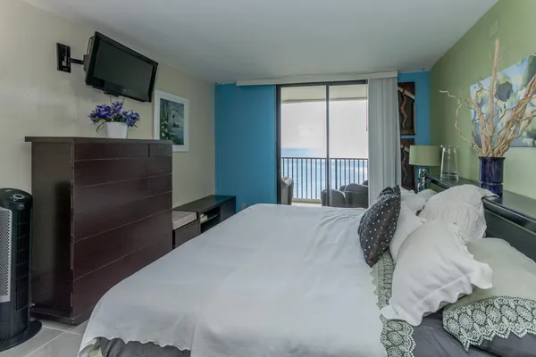 a bedroom with a bed and flat screen tv