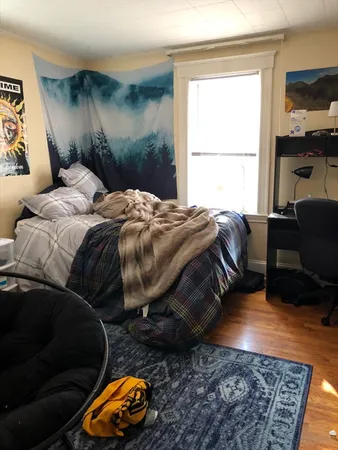 a bedroom with a bed and wooden floor