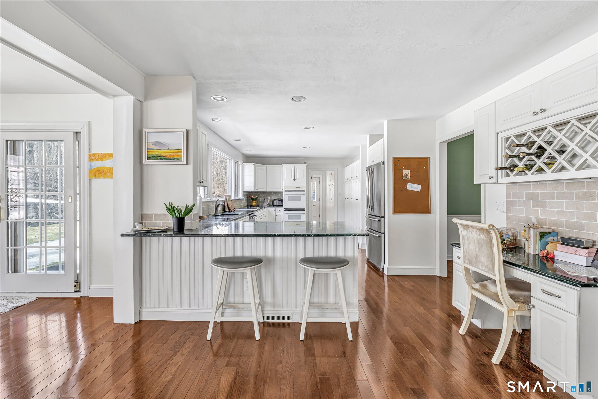 39 Marion Road Westport, CT 06880 - Photo 16 of 46 a kitchen with stainless steel appliances granite countertop a stove top oven a dining table and chairs with wooden floor